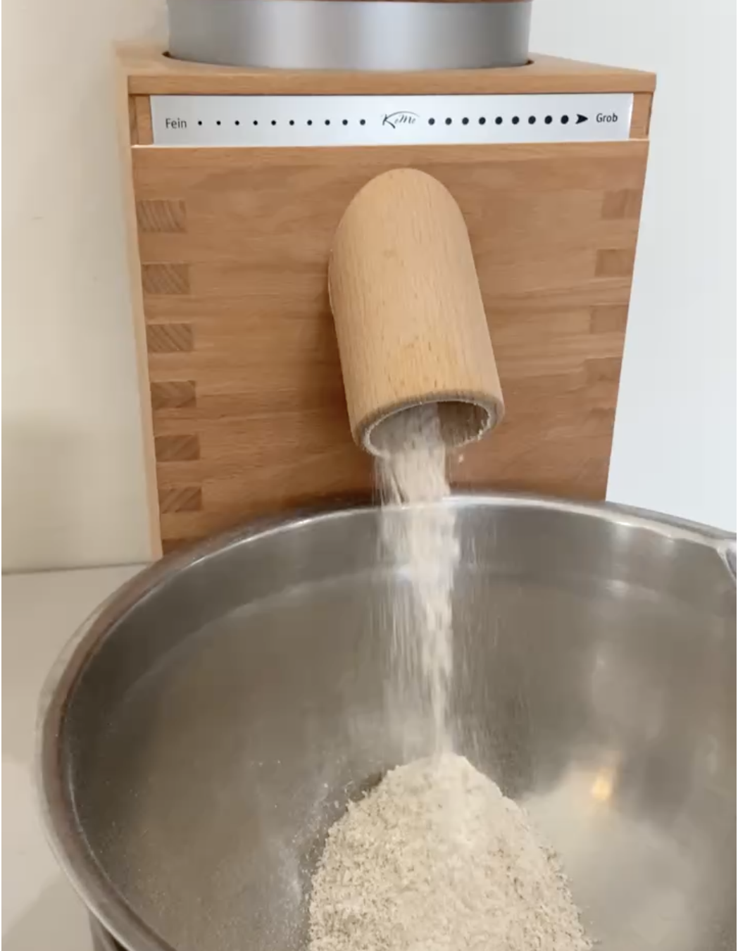 Komo grain mill grinding flour into a metal bowl